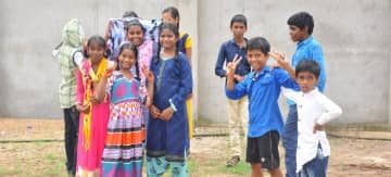 图为一群孤儿，他们在搬进印度新的科卢鲁孤儿院时，满脸笑容。